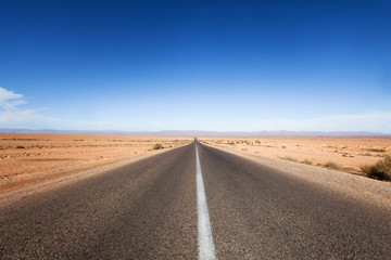 route droite au milieu d'un désert de sable 