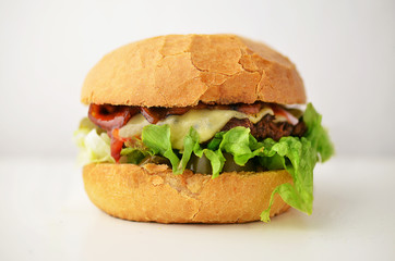 Burger with bacon and cheese on wooden table.