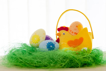 Decorative eggs on green grass. Chicken basket. Concepts Easter, eggs, hand made