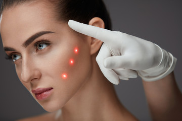Closeup Of Beautician Hands Pointing At Young Woman Face
