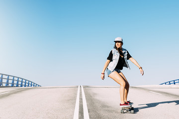Beautiful skater woman riding on her longboard. © santypan