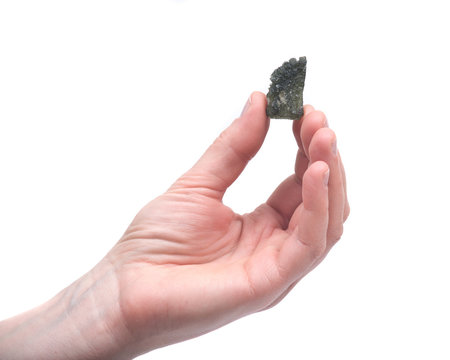 Young woman holding moldavite - form of tektite found along the banks of the river Moldau in Czech republic, isolated on white background