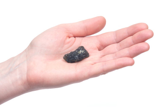 Young woman holding moldavite - form of tektite found along the banks of the river Moldau in Czech republic, isolated on white background