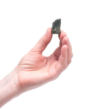 Young woman holding moldavite - form of tektite found along the banks of the river Moldau in Czech republic, isolated on white background