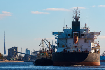 Fototapeta premium Black cargo ship entering the port of Riga, Europe