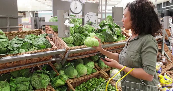 Woman in grocery store using smartphone