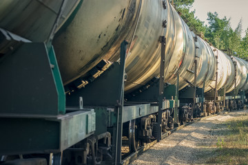 Fototapeta na wymiar Tank wagons with oil. Freight train in forest