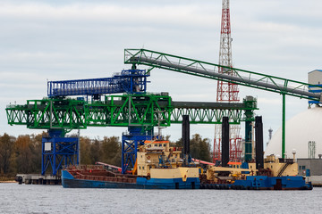 Fototapeta na wymiar Blue cargo ship loading in the port of Riga, Europe
