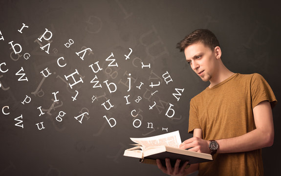 Young man holding book with letters