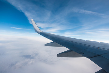 Wing of an aircraft and cloudy sky