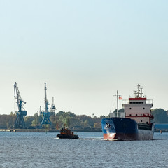 Naklejka premium Blue cargo ship leaving the port of Riga
