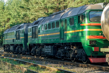 Green diesel cargo locomotive in forest