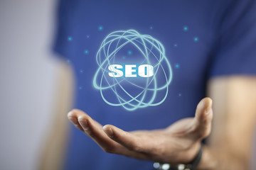 Business man holding SEO text on screen