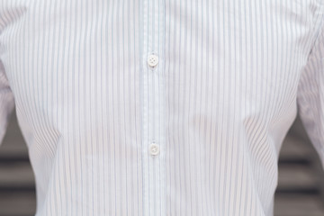 Close up part of a white business shirt on a man. Elegant beautiful shirt with buttons.