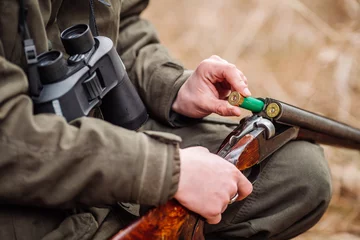 Foto auf Acrylglas Jäger laden Gewehr in einem Winterwald. Bushcraft-, Jagd- und People-Konzept © kaninstudio