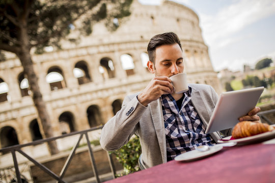 Young man sitting and having a cup of coffee in Rome, Italy