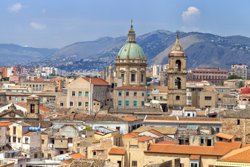 Fototapeta na wymiar Sicilian town of Palermo skyline over roofs of historic buildings with the mountains in the background