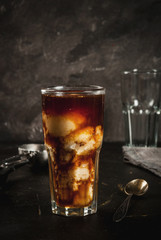 Cold coffee, frappe, frapuchchino. Affogato coffee with ice cream, On a concrete gray table. Toned, vintage. Coffee pot, spoon for ice cream, second glass. Vertical, copy space