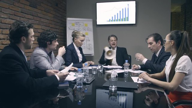 Mad boss yelling at employees with a megaphone