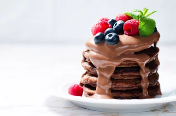 Foto auf Acrylglas chocolate pancake with blueberries, raspberies and chocolate sauce © nata_vkusidey