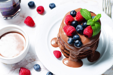chocolate pancake with blueberries, raspberies and chocolate sauce