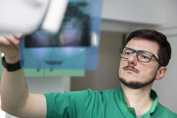 Dentist analyzing x-ray of teeth