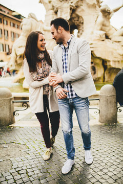 Casual Young Couple Holding Hands Walking In Rome, Italy, Europe