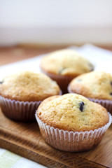 Homemade muffins with blueberries on a wooden board