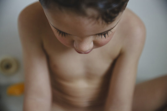 Close-up of naked boy sitting in bathtub