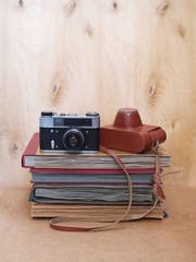 Vintage old film photo-camera with leather case on wooden background