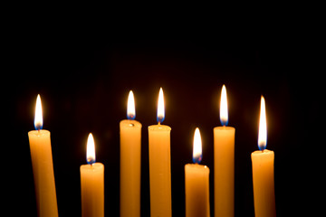 Chandelier with burning candles on black background