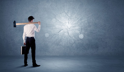 Fototapeta premium Business man hitting wall with a hammer