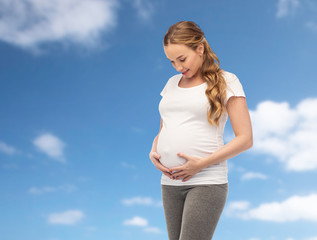 happy pregnant woman touching her big belly
