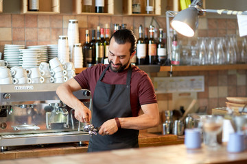 barista with holder and tamper making at coffee