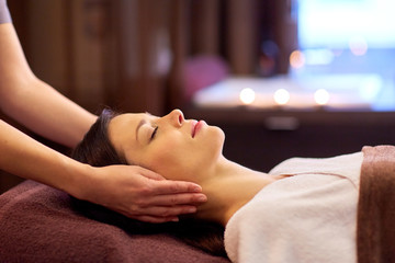 Obraz na płótnie Canvas woman having face and head massage at spa