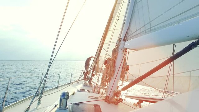 Mann auf Segelyacht / Segelboot segelt in die Abendsonne