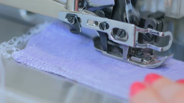 Professional tailor, seamstress using overlocking sewing machine. Fashion and tailoring concept