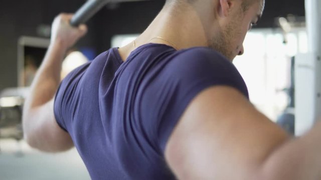 A young athletic man is training in the gym. 4K