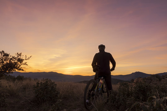 The cyclist on the mountain at sunset
