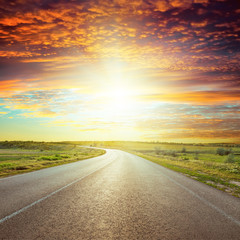 asphalt road to red horizon in sunset