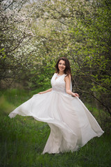 Girl in white dress in blooming garden
