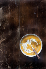 Creamy pumpkin/butternut squash soup. Copy space. Rustic weathered wood background 