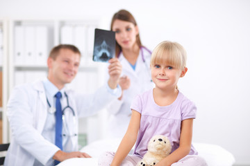 Female doctor examining child with stethoscope at surgery