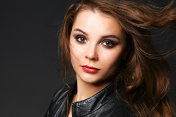 Fototapeta premium Portrait of beautiful brunette female wearing leather jacket