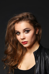 Fototapeta premium Portrait of beautiful brunette female wearing leather jacket