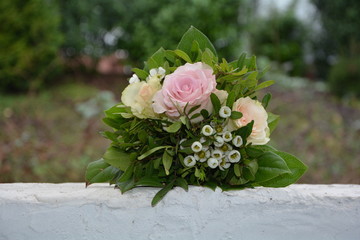 Rosen - Bouquet liegt auf weißer Mauer in der Natur