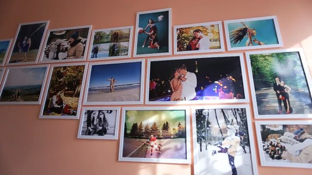 Colorful photos and pictures on the wall at small room. peach background