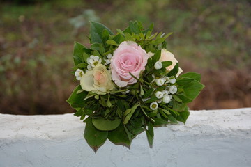 Rosen - Bouquet liegt auf weißer Mauer in der Natur