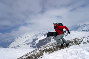 A female snowboarder running to the powder snow at high altitude 