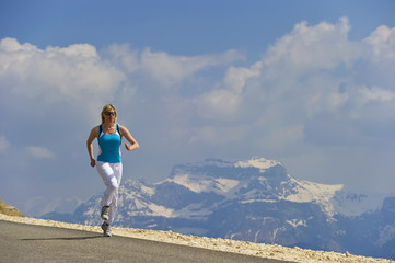 Fototapeta premium A women running along a mountain road.